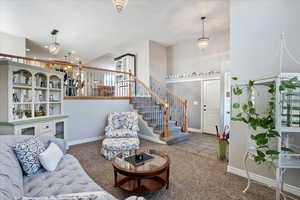 Carpeted living room featuring stairway, recessed lighting, and baseboards