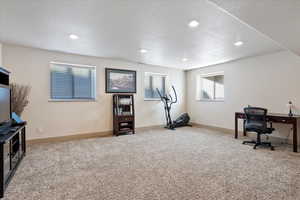 Office space with baseboards, visible vents, a textured ceiling, carpet flooring, and recessed lighting