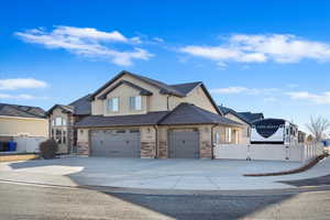 View of front of home featuring fence, concrete driveway, and stucco siding