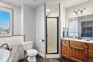 Bathroom with a garden tub, toilet, a shower stall, vanity, and tile patterned flooring