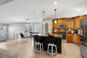 Kitchen with appliances with stainless steel finishes, brown cabinetry, a wealth of natural light, and decorative backsplash