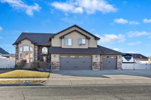 View of front facade with a gate, fence, and stucco siding