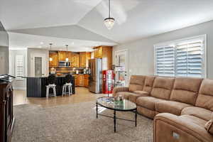 Living area with lofted ceiling, recessed lighting, baseboards, and light tile patterned flooring