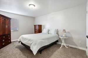 Bedroom featuring carpet and baseboards