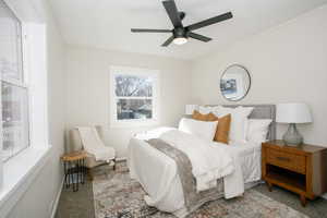 Carpeted bedroom featuring a ceiling fan and baseboards