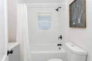 Full bath with vanity, shower / bath combination with curtain, and toilet