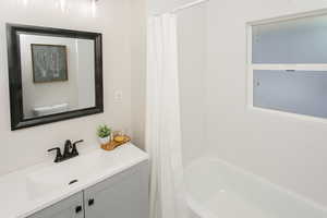 Bathroom featuring shower / bath combo with shower curtain and vanity