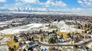 Snowy aerial view with a mountain view and a residential view