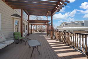 Wooden terrace with outdoor dining area and a pergola