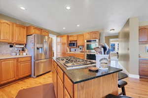 Kitchen with a center island, decorative backsplash, appliances with stainless steel