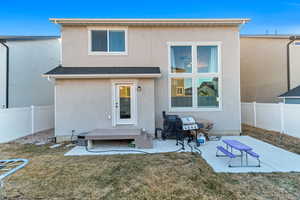 Rear view of property with a patio, a fenced backyard, a shingled roof, a lawn, and stucco siding