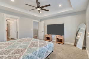 Bedroom featuring baseboards, a raised ceiling, a ceiling fan, carpet flooring, and recessed lighting