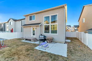 Rear view of property with a yard, stucco siding, a patio area, a residential view, and a fenced backyard