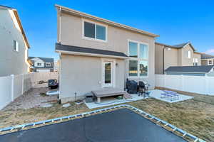 Rear view of house featuring a patio, a fenced backyard, a yard, roof with shingles, and stucco siding