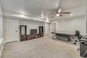 Interior space featuring a ceiling fan, recessed lighting, carpet flooring, and a textured ceiling