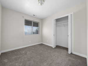 Unfurnished bedroom featuring carpet, a closet, visible vents, and baseboards