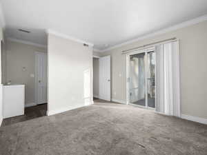 Master Bedroom with baseboards, crown molding, carpet flooring, and sliding glass door to the balcony.