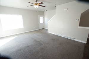 Unfurnished room with carpet, visible vents, ceiling fan, and baseboards