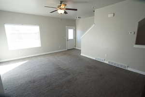 Carpeted spare room featuring baseboards and visible vents