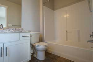 Full bathroom with shower / tub combination, vanity, toilet, and tile patterned floors