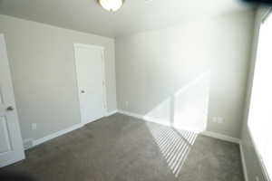 Carpeted empty room with baseboards