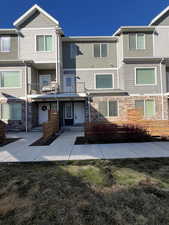 Townhome / multi-family property with stone siding and stucco siding