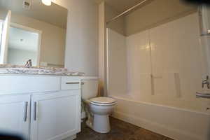 Bathroom featuring visible vents, vanity, toilet, and shower / bathtub combination