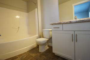 Bathroom featuring  shower combination, vanity, and toilet