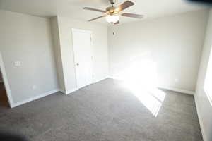 Unfurnished bedroom featuring carpet floors, baseboards, and a ceiling fan