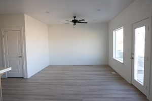 Unfurnished room with baseboards, ceiling fan, and light wood finished floors