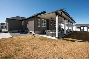 Back of house featuring a yard, a patio, outdoor lounge area, central AC unit, and fence