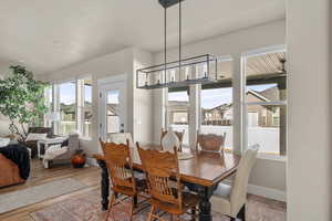 Dining space with baseboards, a chandelier, and wood finished floors