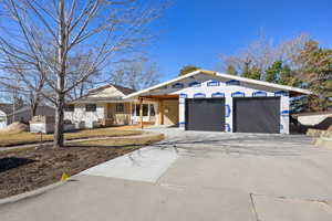 View of front of home with driveway, brick siding, and an attached garage