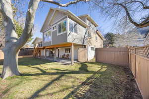 Back of property featuring a patio, a yard, and a fenced backyard