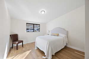 Bedroom featuring wood finished floors and baseboards