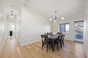 Dining space with crown molding, light wood-style flooring, and baseboards