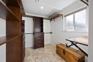 Walk in closet featuring stone tile floors