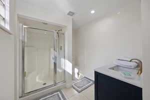 Full bathroom with toilet, a sink, visible vents, a shower stall, and tile patterned floors