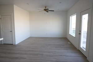 Unfurnished room featuring a ceiling fan, baseboards, and wood finished floors