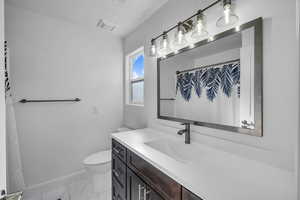 Full bath with toilet, vanity, visible vents, baseboards, and marble finish floor