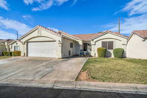 Mediterranean / spanish-style home with driveway, stucco siding, a tile roof, an attached garage, and a front yard