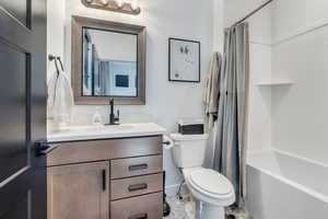 Full bath featuring shower / tub combo, vanity, and toilet