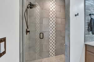 Full bath with a shower stall and vanity