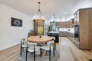 Dining area with light wood-type flooring, recessed lighting, baseboards, and an inviting chandelier