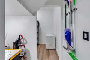 Interior space with laundry area, wood finished floors, and baseboards