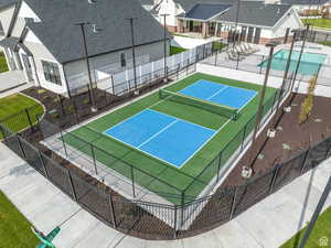 View of tennis court featuring a patio area, a residential view, a community pool, and fence