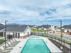 Community pool with a patio area, a residential view, and fence