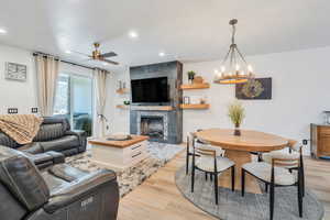 Living room with recessed lighting, a tile fireplace, and light wood-style floors