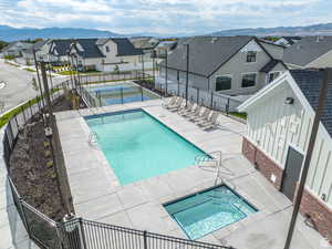 Pool with a residential view, a mountain view, a tennis court, and fence