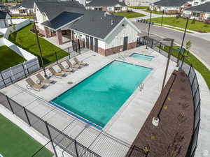 Community pool featuring a patio area, a fenced backyard, and a residential view